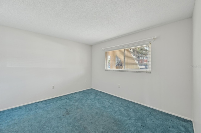 carpeted empty room with a textured ceiling