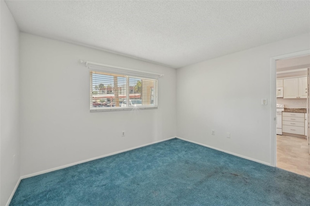 carpeted empty room featuring a textured ceiling