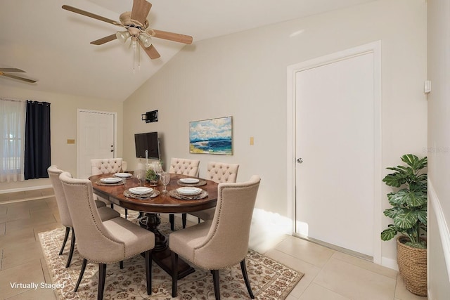 tiled dining space with ceiling fan and vaulted ceiling