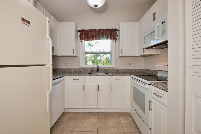 kitchen featuring lofted ceiling, sink, white appliances, light tile patterned floors, and white cabinetry