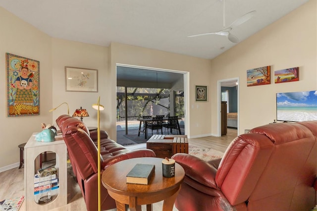 living area with light wood-style floors, ceiling fan, baseboards, and vaulted ceiling