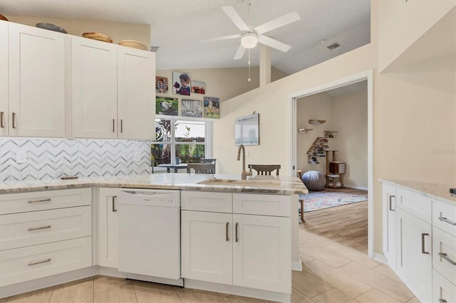 kitchen with backsplash, white dishwasher, a sink, and white cabinets