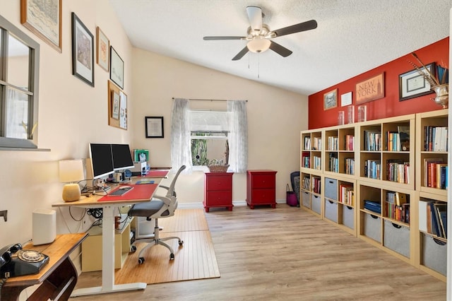 home office featuring baseboards, a ceiling fan, lofted ceiling, wood finished floors, and a textured ceiling