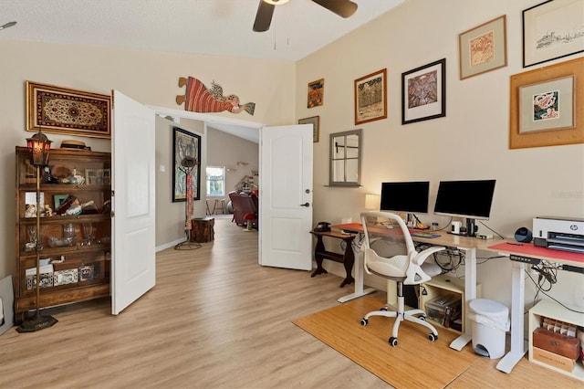 office space featuring lofted ceiling, light wood finished floors, baseboards, and a ceiling fan