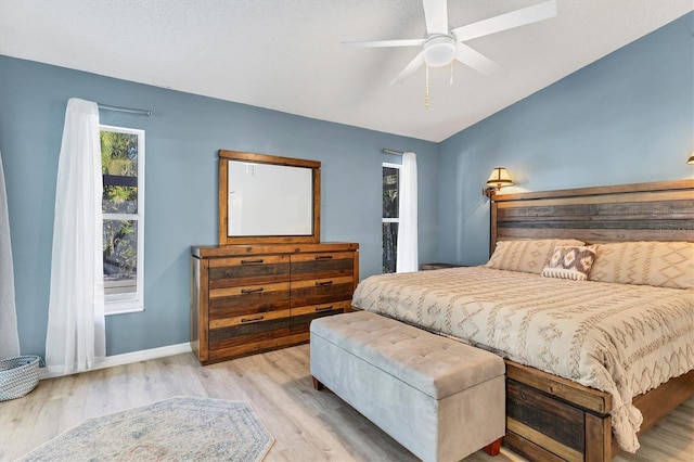 bedroom with lofted ceiling, ceiling fan, wood finished floors, and baseboards