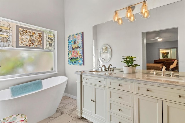 bathroom with marble finish floor, double vanity, a soaking tub, and a sink