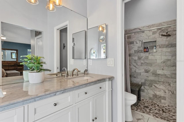 bathroom with tiled shower, toilet, ceiling fan, marble finish floor, and vanity