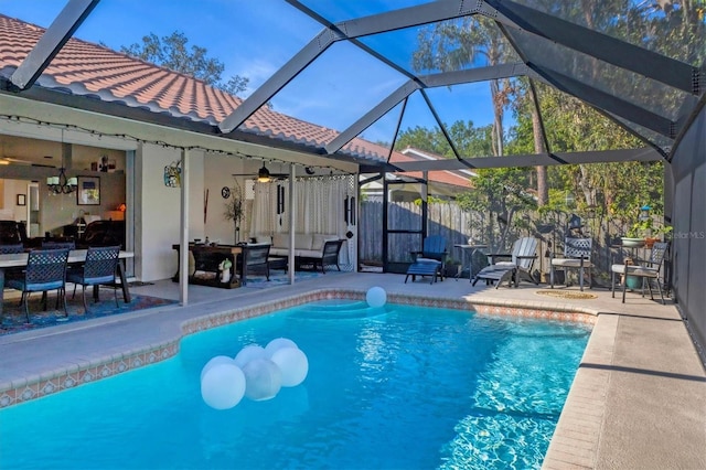 view of swimming pool featuring ceiling fan, a patio, glass enclosure, and a fenced in pool