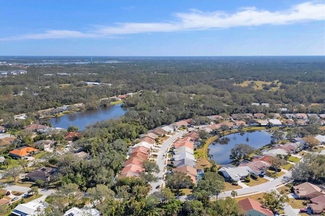 birds eye view of property with a residential view, a water view, and a view of trees