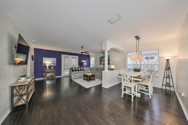 interior space with ceiling fan, plenty of natural light, wood-type flooring, and ornate columns