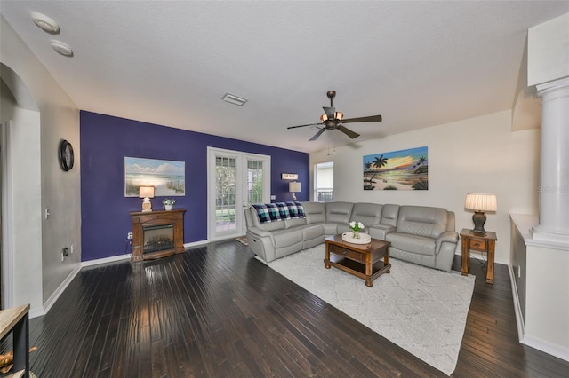 living room featuring a textured ceiling, dark hardwood / wood-style floors, ceiling fan, and ornate columns