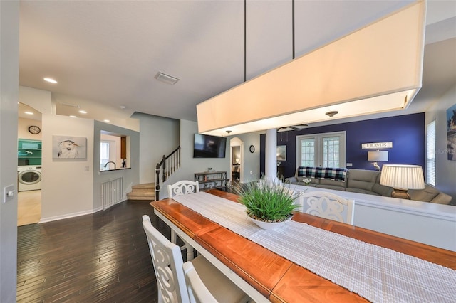 dining area featuring washer / clothes dryer, dark hardwood / wood-style flooring, and french doors