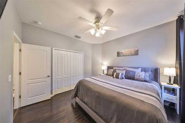 bedroom featuring dark hardwood / wood-style floors, a textured ceiling, ceiling fan, and a closet