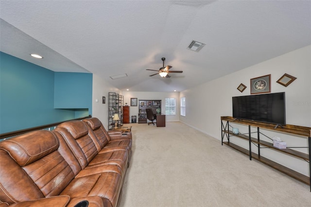 carpeted living room with a textured ceiling and ceiling fan