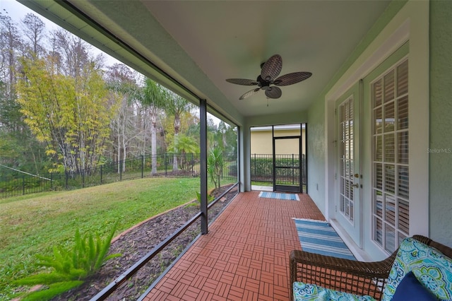 unfurnished sunroom featuring ceiling fan