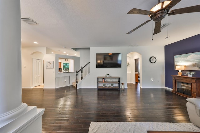 living room with dark hardwood / wood-style floors, a textured ceiling, and ceiling fan