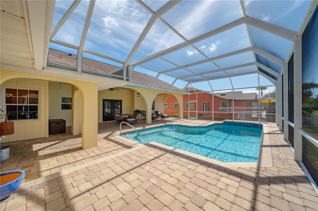 view of pool with a patio area, ceiling fan, and glass enclosure