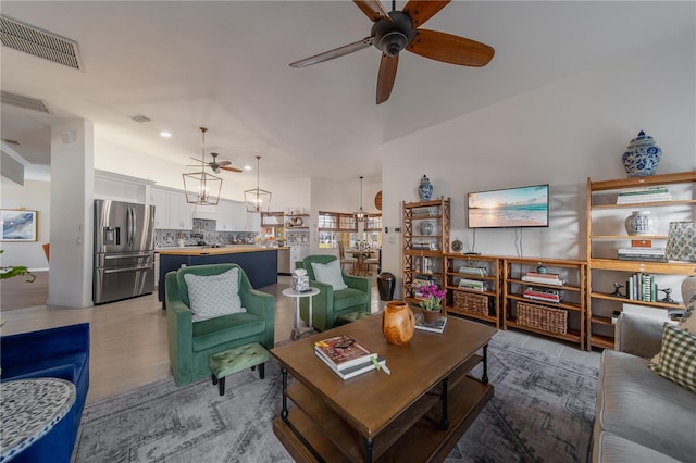 living room with ceiling fan and light hardwood / wood-style flooring