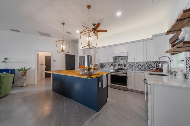 kitchen featuring wood counters, white cabinetry, sink, custom exhaust hood, and stainless steel appliances