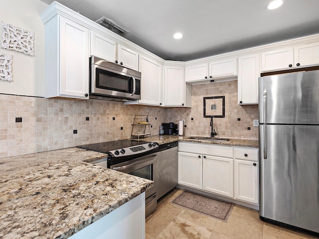 kitchen featuring stainless steel appliances, light stone countertops, sink, and white cabinets