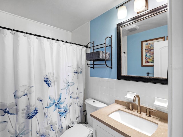 bathroom featuring vanity, toilet, tile walls, and walk in shower