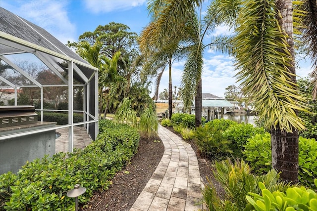 view of yard featuring a water view and glass enclosure