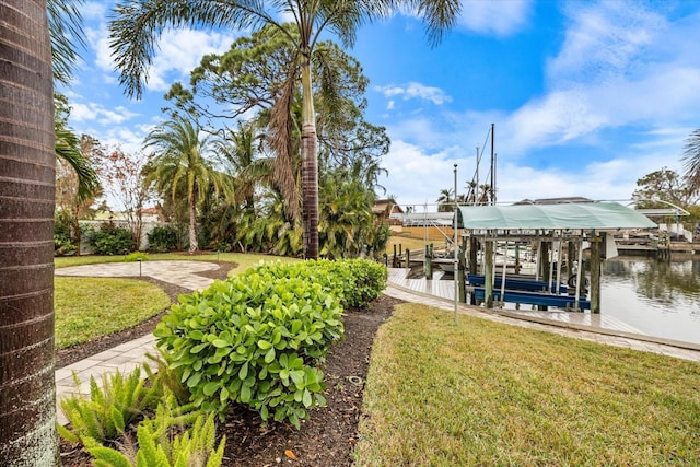 view of dock with a water view and a lawn