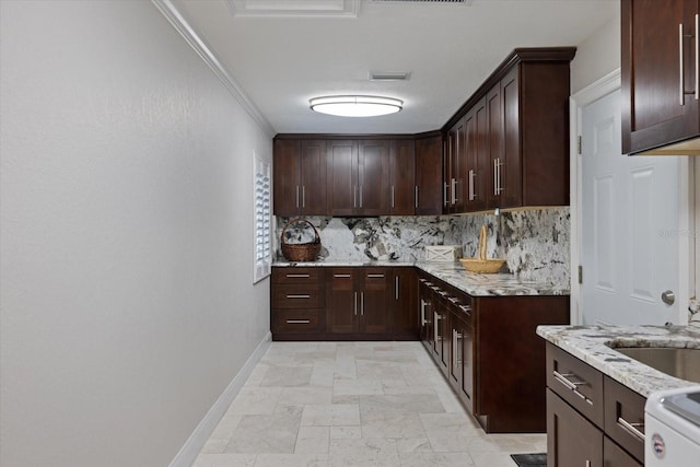 kitchen with decorative backsplash, stove, crown molding, light stone countertops, and dark brown cabinets