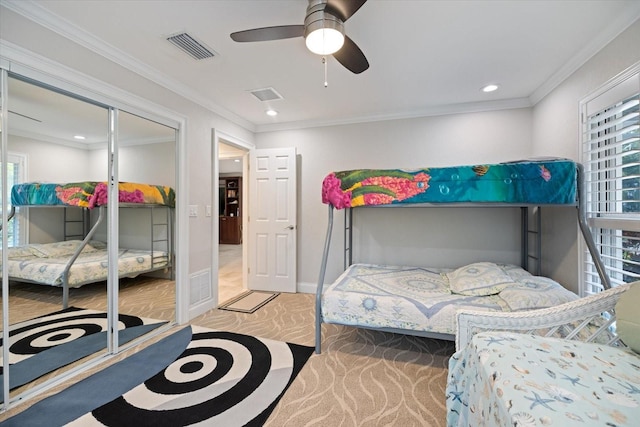 bedroom featuring ornamental molding, a closet, ceiling fan, and carpet