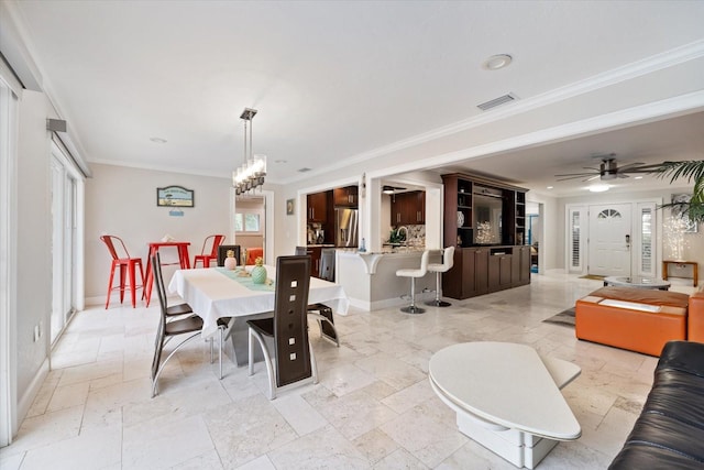 dining area featuring crown molding and ceiling fan with notable chandelier