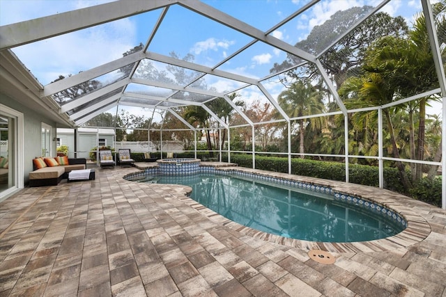 view of pool with a patio area, an in ground hot tub, outdoor lounge area, and glass enclosure