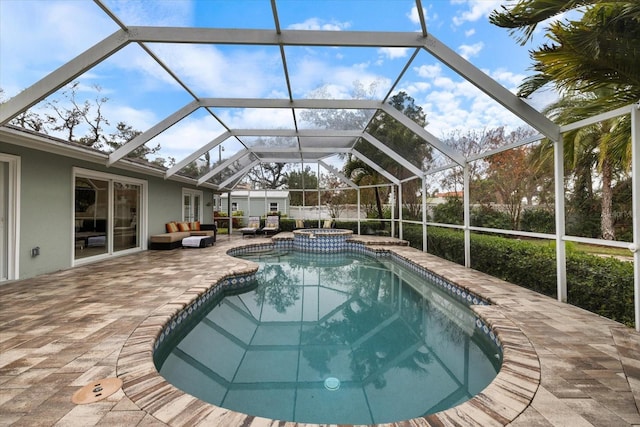 view of pool with an in ground hot tub, a patio, an outdoor hangout area, and glass enclosure