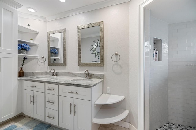 bathroom with crown molding, a tile shower, and vanity