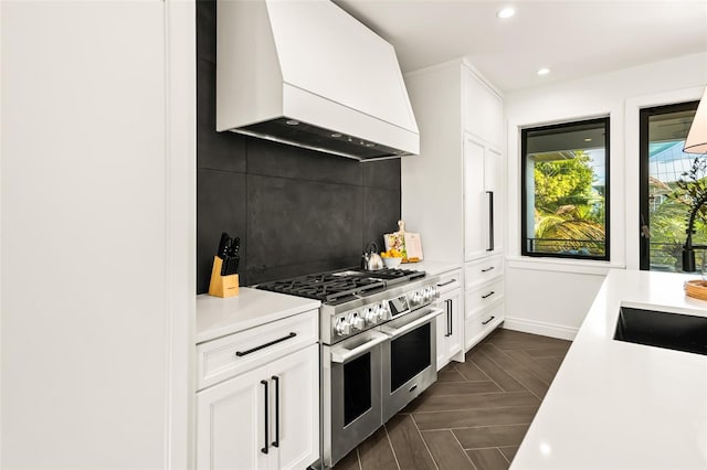 kitchen with white cabinetry, tasteful backsplash, double oven range, and custom exhaust hood