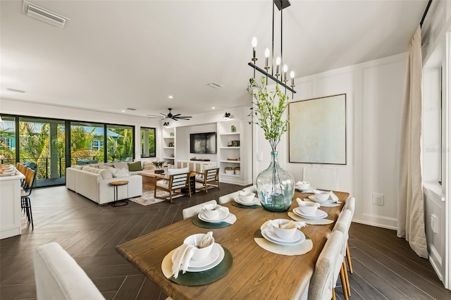 dining space with ceiling fan with notable chandelier