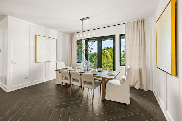 dining room featuring a notable chandelier and dark parquet floors