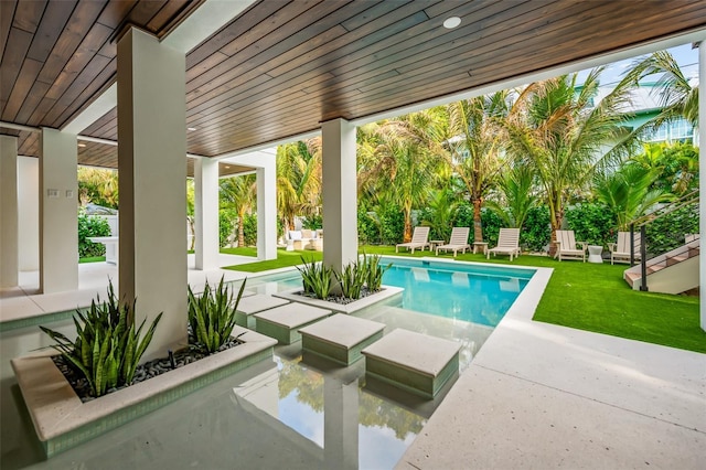 view of pool with a lawn and a patio area