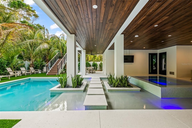 view of swimming pool with a hot tub and a patio area