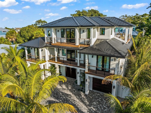 back of house with a balcony and a garage