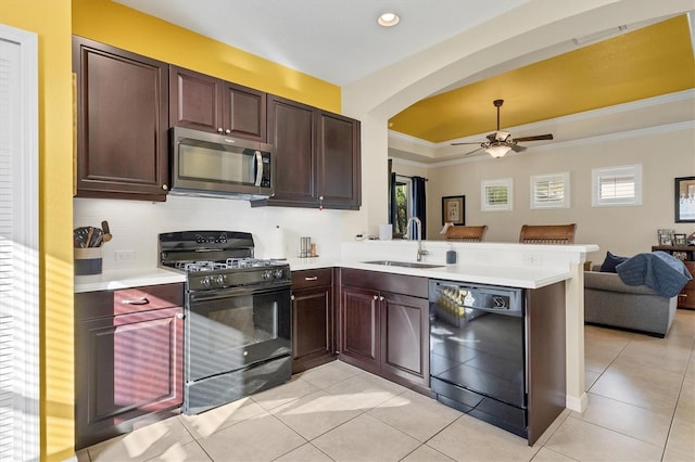 kitchen featuring light tile patterned flooring, sink, a tray ceiling, kitchen peninsula, and black appliances