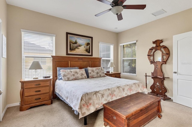 bedroom with multiple windows, light colored carpet, and ceiling fan