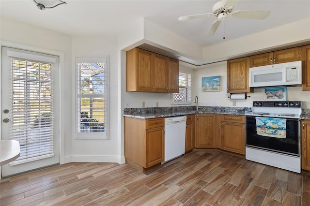 kitchen with stone counters, ceiling fan, sink, and white appliances