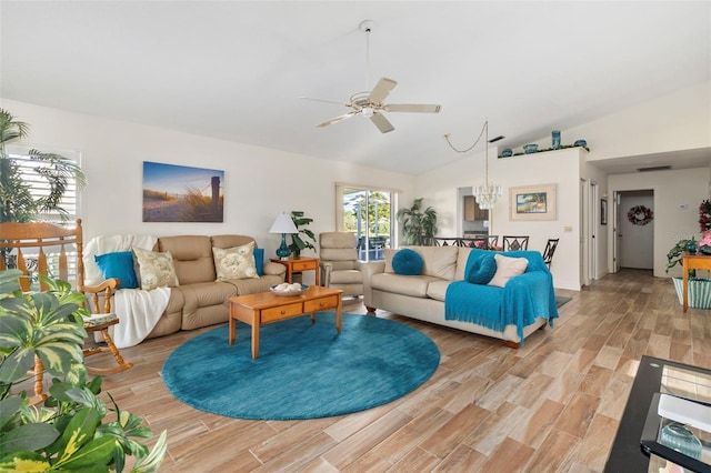 living room featuring ceiling fan with notable chandelier, light hardwood / wood-style flooring, and vaulted ceiling