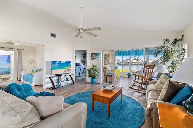 living room with ceiling fan, high vaulted ceiling, and light hardwood / wood-style floors