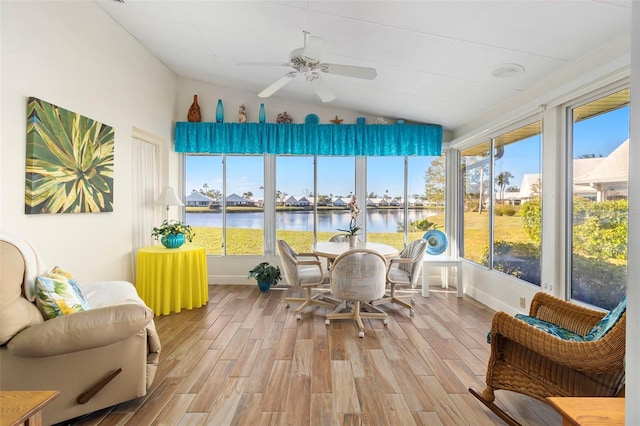 sunroom / solarium with a water view, ceiling fan, and vaulted ceiling