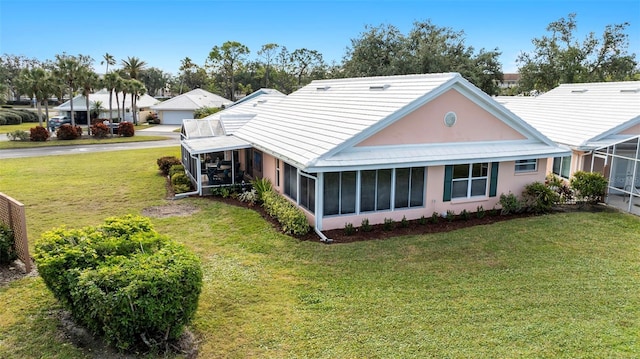 back of house with a lawn and a sunroom