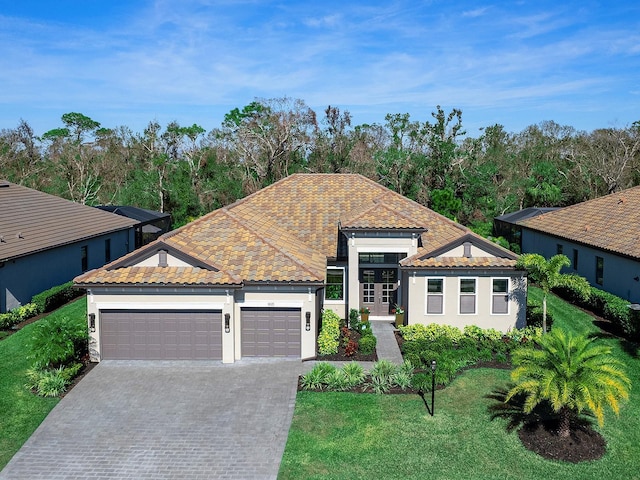 view of front of property featuring a garage, decorative driveway, a tiled roof, and a front lawn