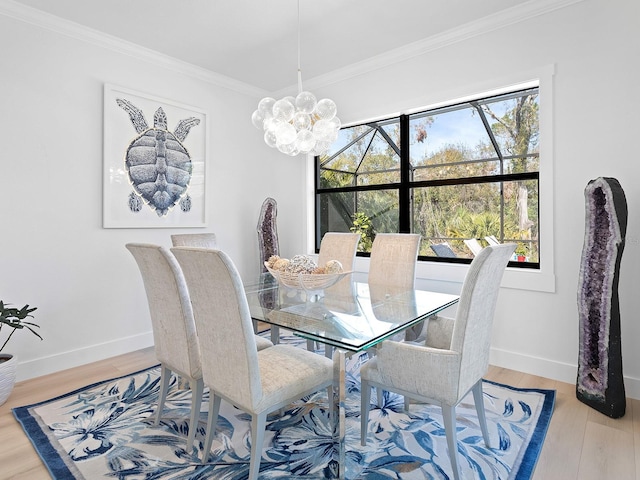 dining space with hardwood / wood-style flooring, ornamental molding, and a notable chandelier