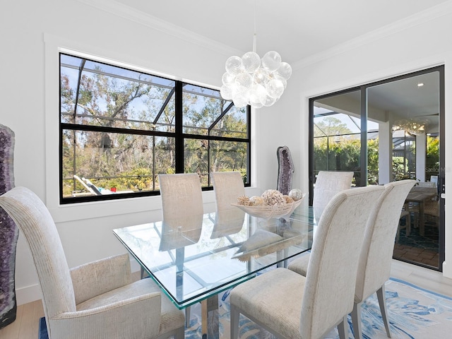 dining space with a wealth of natural light, wood finished floors, crown molding, and an inviting chandelier