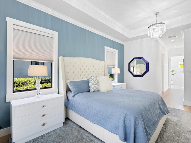 bedroom with wood-type flooring, ornamental molding, and a chandelier